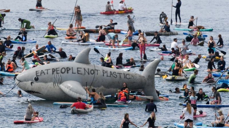 Фото: Reuters/Протестующие экоактивисты надули гигантсткую акулу с надписью: "Ешь людей, а не пластик". По их мнению, климатическая повестка саммита G7 провалилась