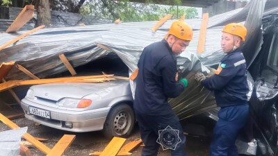 Металлическую кровлю здания сорвало ветром в Актобе: двоих человек спасли из раздавленного авто