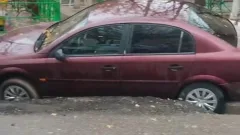 Шымкентте жауыннан кейін асфальт опырылып, бірнеше көлік шұңқырға түсіп кетті