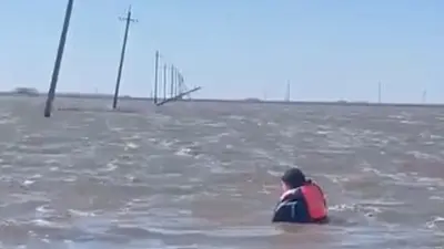 Столбы линии электропередачи обрушились во время разлива реки в Акмолинской области. Их чинили вплавь 