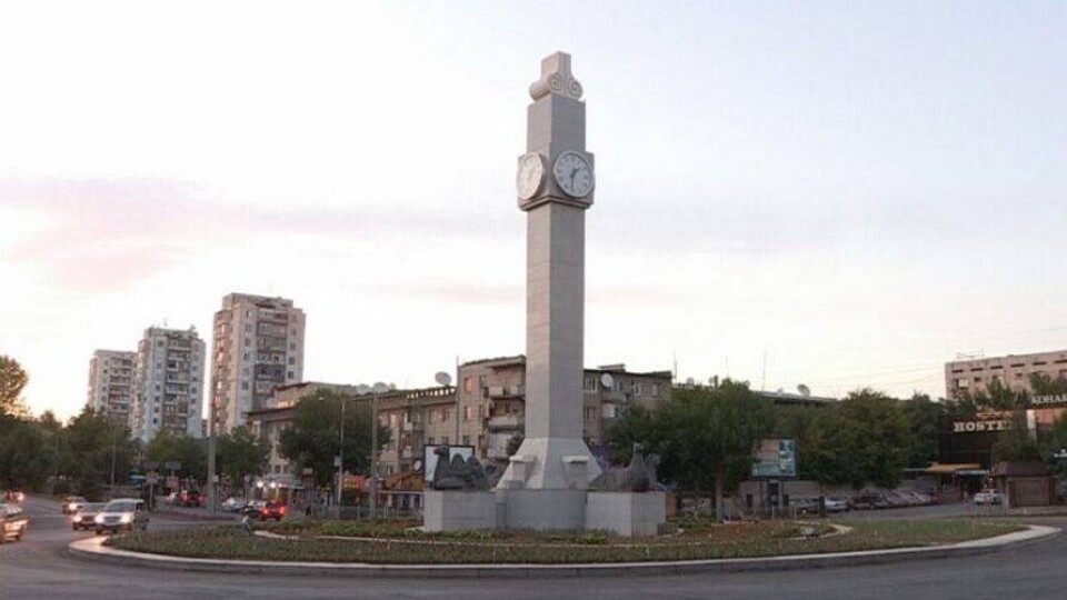 Неработающие городские часы в Шымкенте закрыли баннером с логотипом города