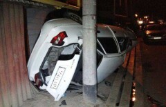 В Алматы во время ДТП автомобиль загнали боком между забором и столбом на тротуаре
