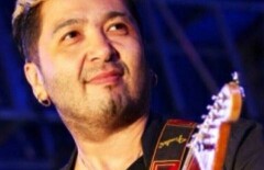 Ребенок играет на домбре, сидя на горшке