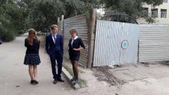 В Уральске в первый день учёбы ученики смотрели на свою школу через щели забора