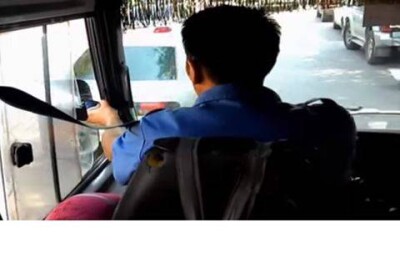 Водитель алматинской маршрутки высовывает в окно зеркало, чтобы проверить обстановку на дороге