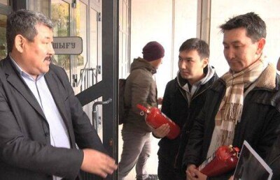 Жители Уральска принесли в здание партии "Нур Отан" огнетушители