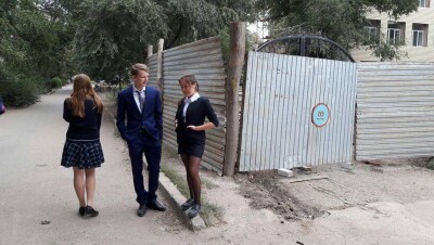 В Уральске в первый день учёбы ученики смотрели на свою школу через щели забора