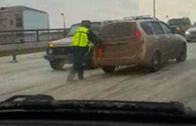 Полицейские Атырау руками толкали съезжающие с ледяного моста автомобили 