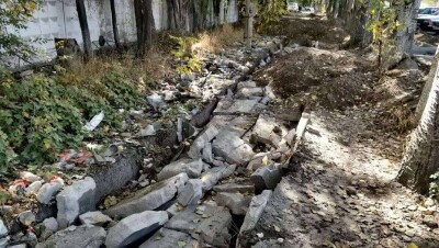 В Алматы оштрафовали подрядную организацию, ремонтирующую тротуар. Рабочие засыпали грунтом мусор