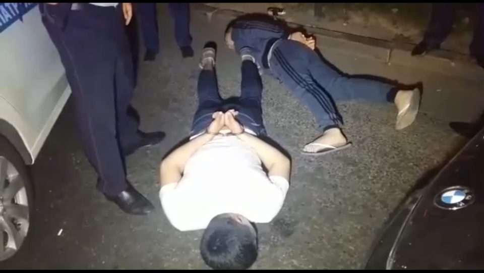 В Алматы сотрудники полиции уложили на землю двух парней и надели на них наручники