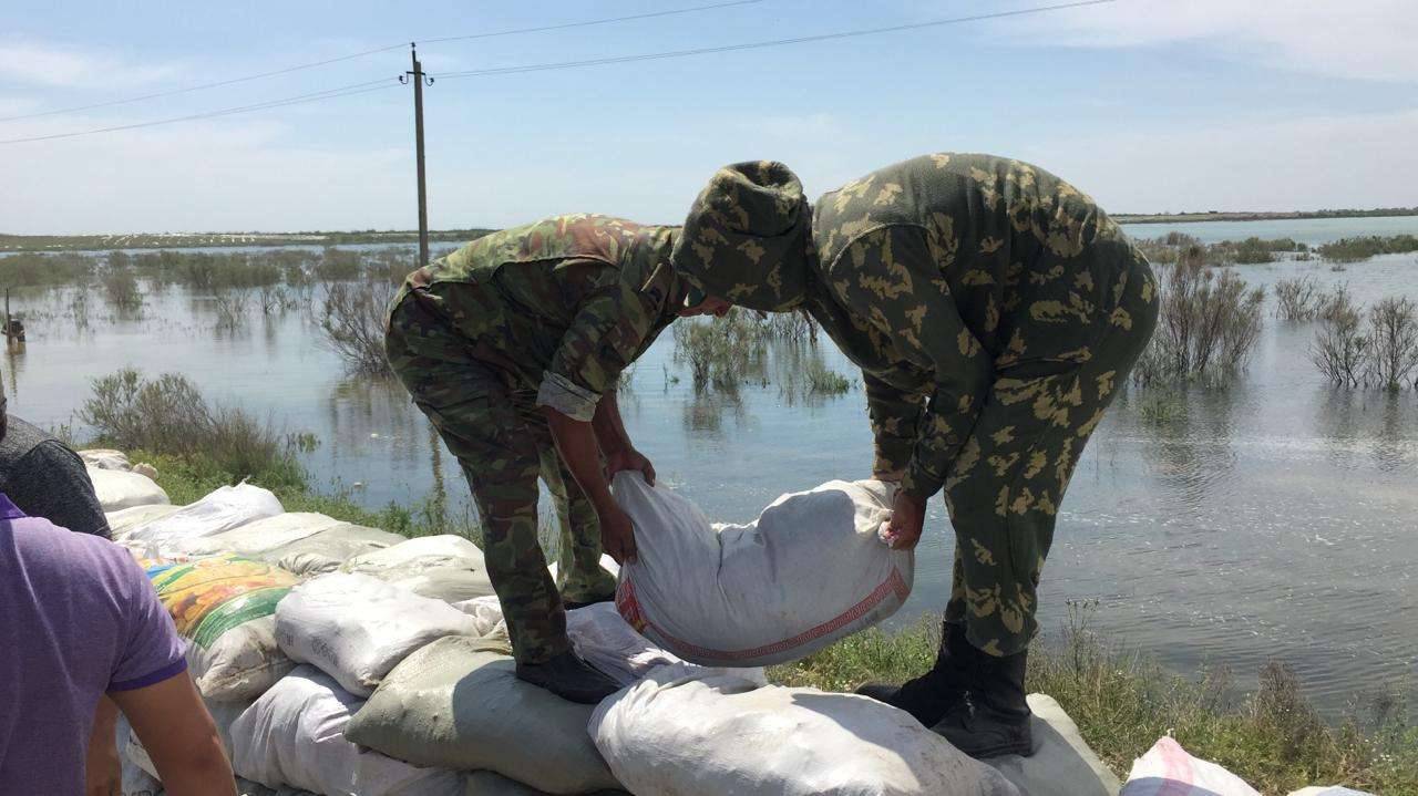 Спасатели укладывают мешки с песком