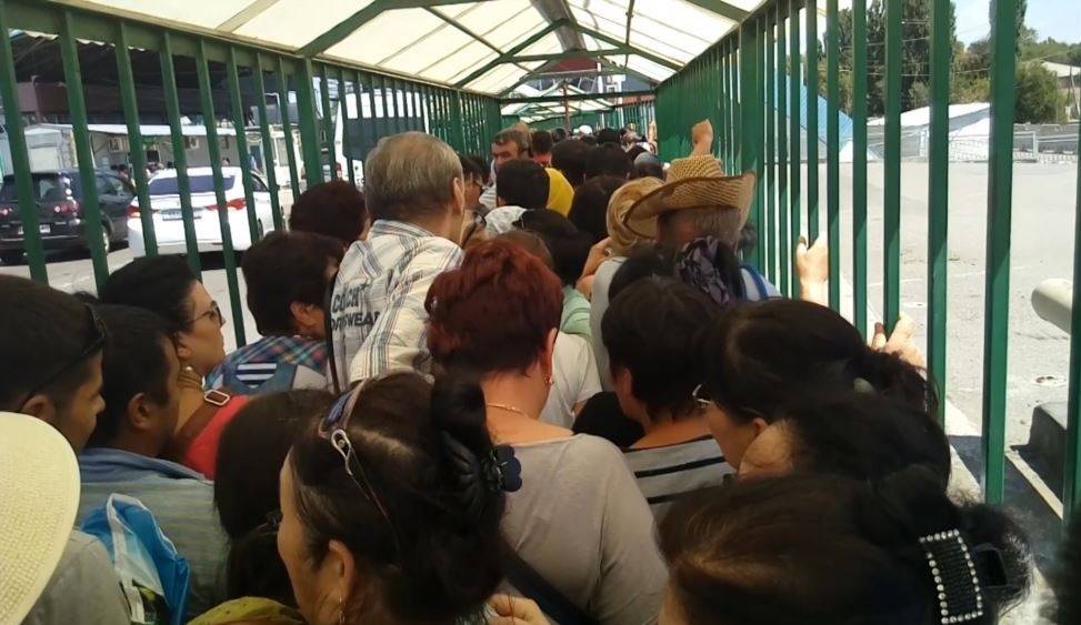 Люди ожидают очереди внутри металлической конструкции на пропускном пункте "Кордай"