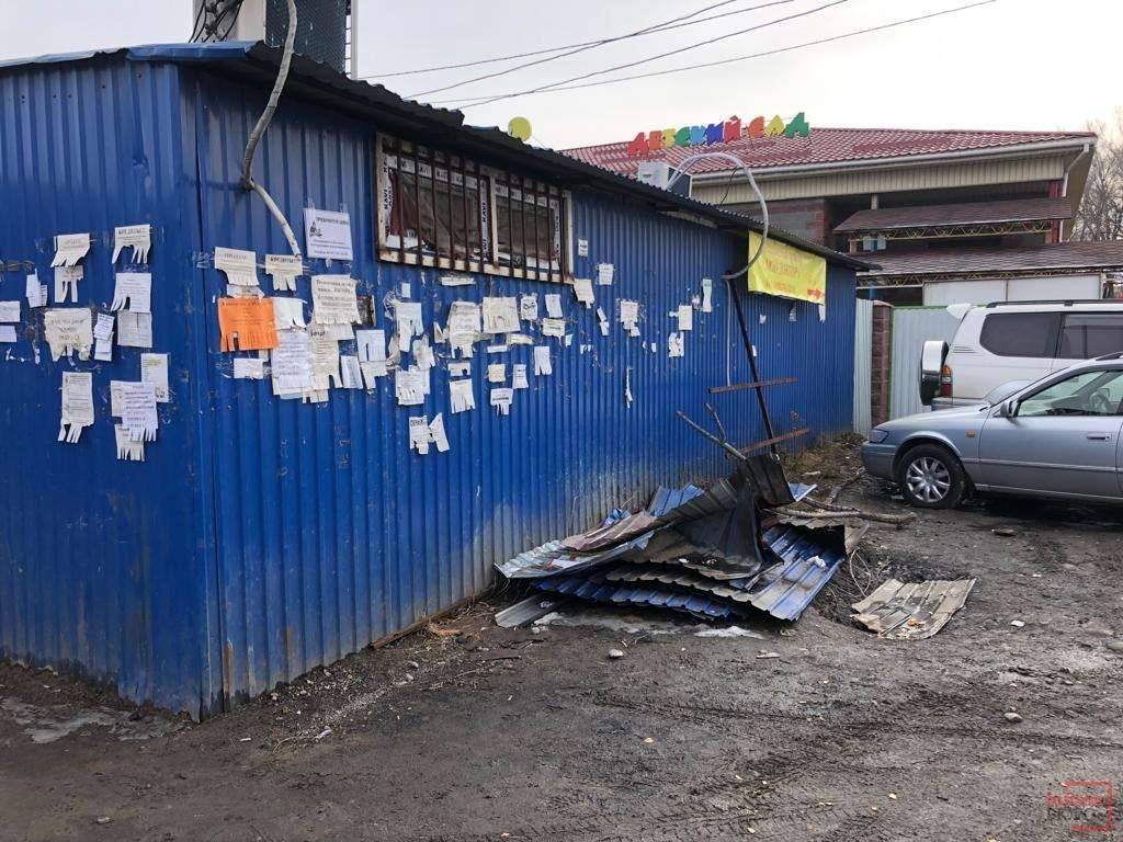 За магазином лежит строительный мусор и расклеены объявления