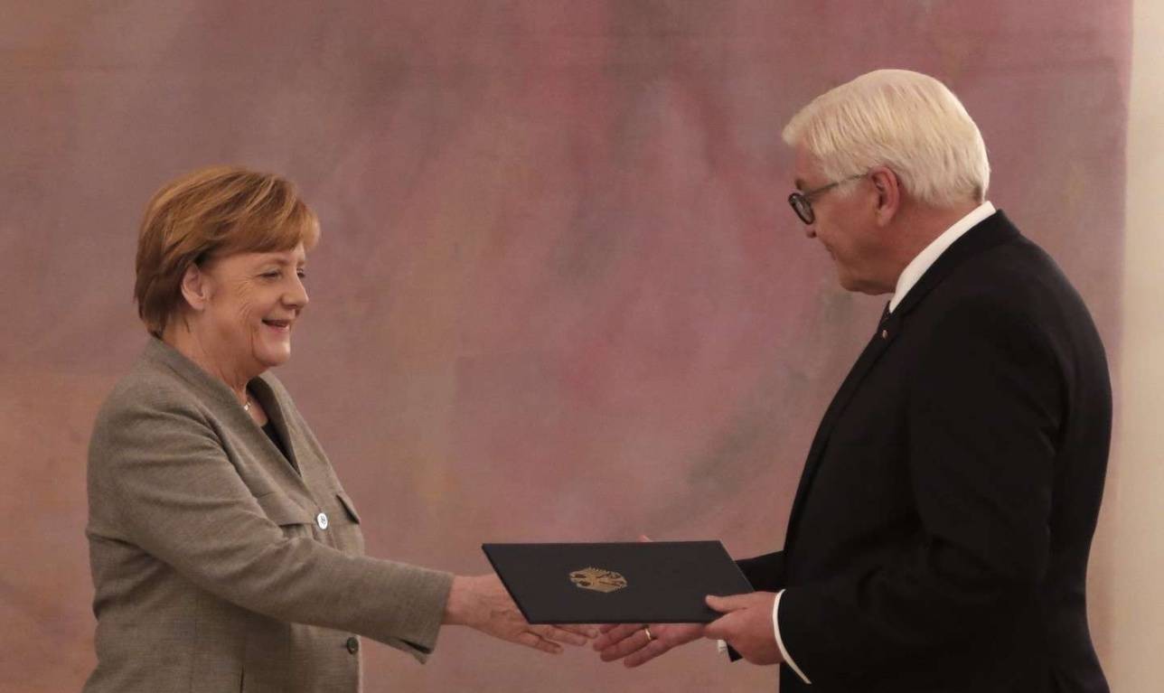 Франк-Вальтер Штайнмайер вручает Ангеле Меркель увольнительную грамоту