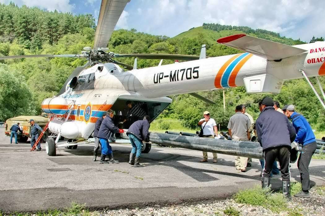 Загружают трубы в вертолёт