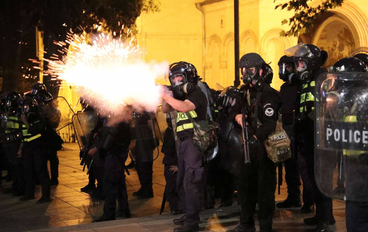 Полицейский стреляет во время митинга в Тбилиси