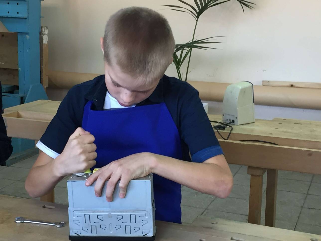 Воспитанник детского дома ремонтирует автомобильную магнитолу.